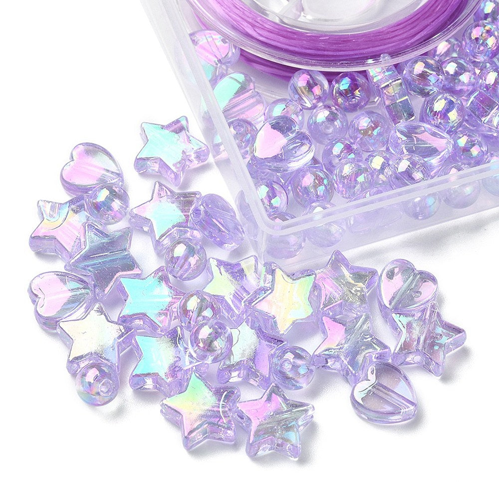 corner of plastic bead box with iridescent light purple heart star and round beads spilling out onto white surface. 
