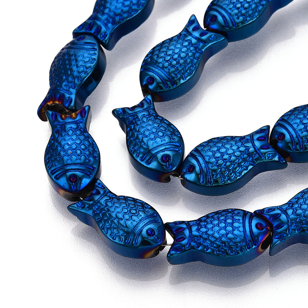 zoomed in sections of blue electroplate glass fish bead strands over white surface. 