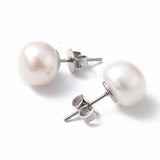 silver tone and white pearl studs over white background. 