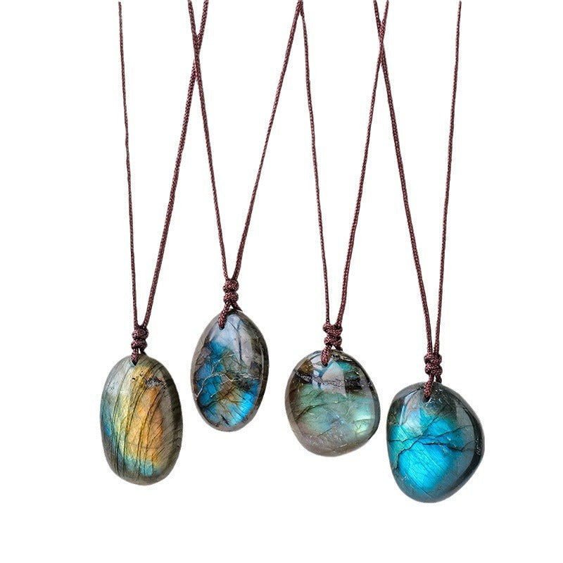 four unique labradorite stone pendants each strung on brown cord over a white background. 