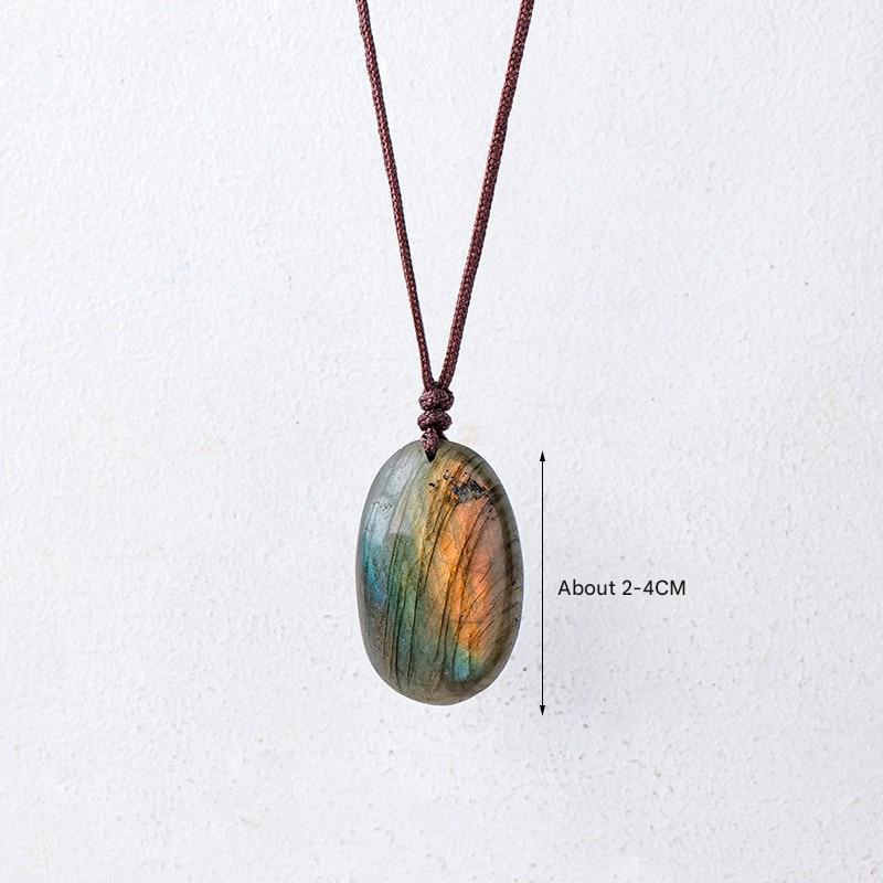 labradorite stone strung on brown cord over a white background depicting size of approximately 2-4 cm in length .
