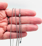 stainless steel Rolo chain with lobster claw clasp and extender chain on a hand on white background. 
