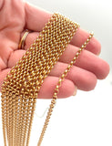 multiple golden medium Rolo chain necklaces on a hand on white background. 