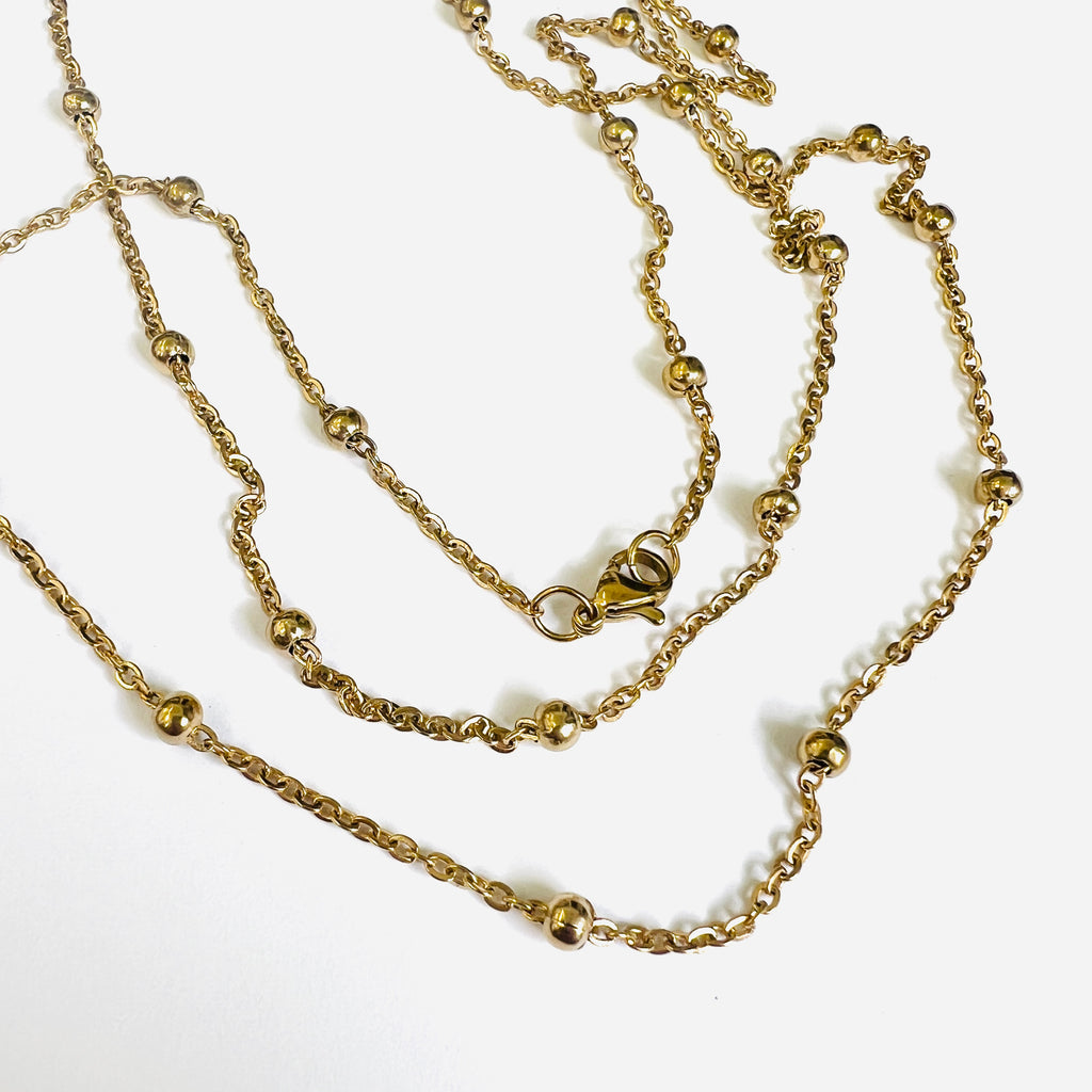 golden large bead satellite chain necklace with lobster claw clasp on white background. 