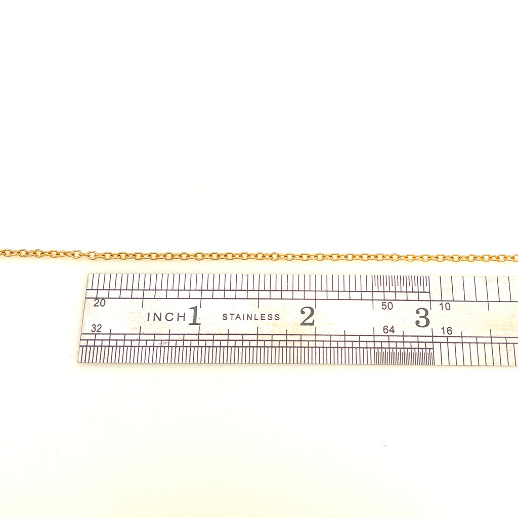 stainless steel cable chain above stainless steel imperial ruler on white background. 