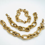 3 golden, large alternating oval and round link chain bracelets with lobster claw clasp on white background. 