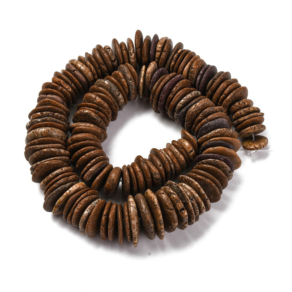 coconut brown dyed, synthetic turquoise graduated bead strand in swirl design over white surface. 