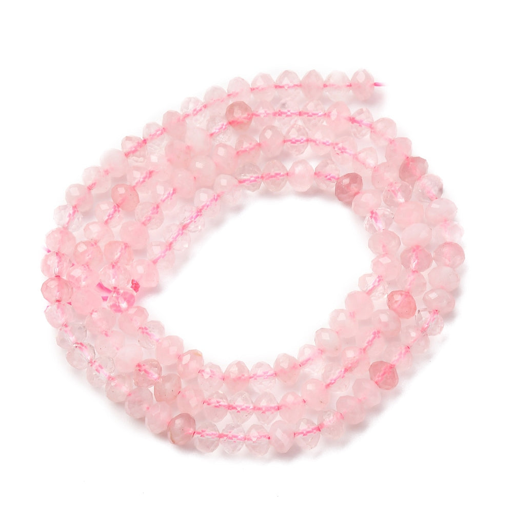 faceted rondelle rose quartz bead strand in spiral design over white background. 