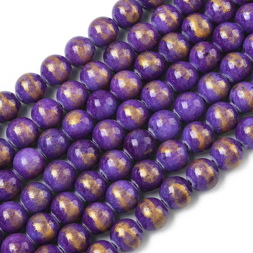 sections of smooth round and dyed purple jade bead strands with gold foil over a white surface. 