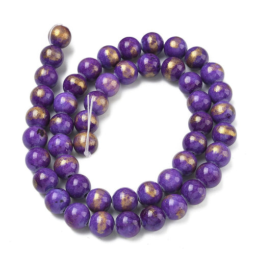 smooth round and dyed purple jade bead strand with gold foil in a swirl display over white surface. 