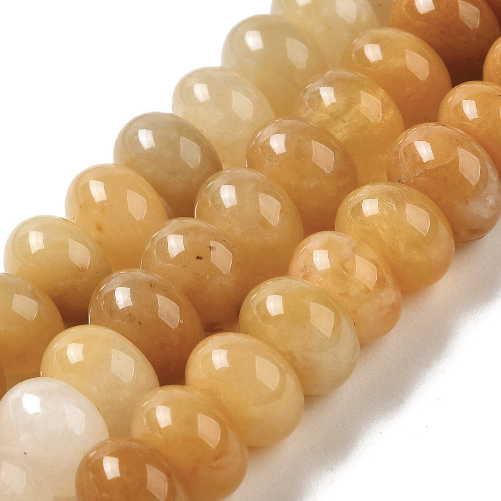 zoomed in sections of assorted dark yellow dyed jade rondelle strands over white surface. 