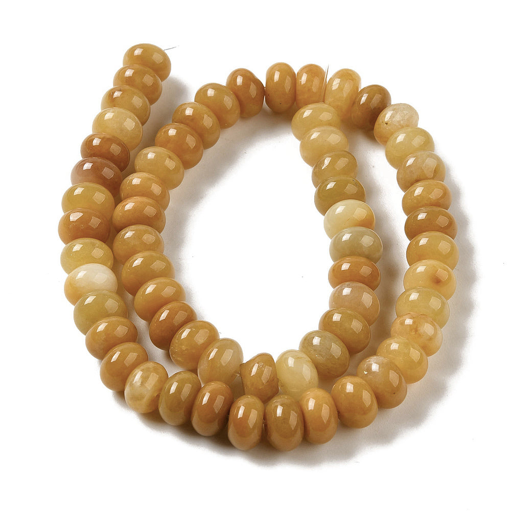 assorted dark yellow dyed jade rondelle strand in swirl display over white surface. 