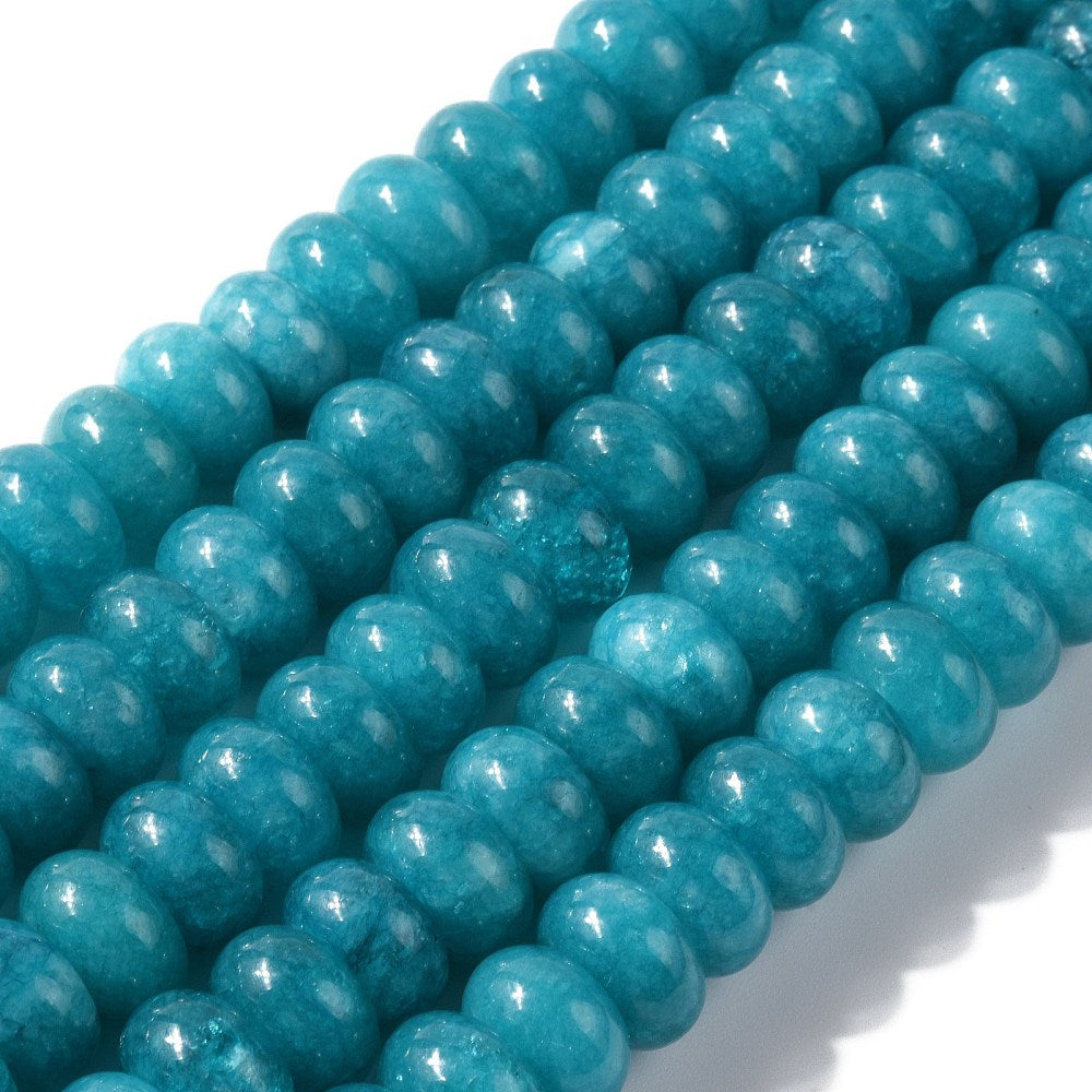 zoomed in sections of teal dyed jade rondelle strands over white surface. 