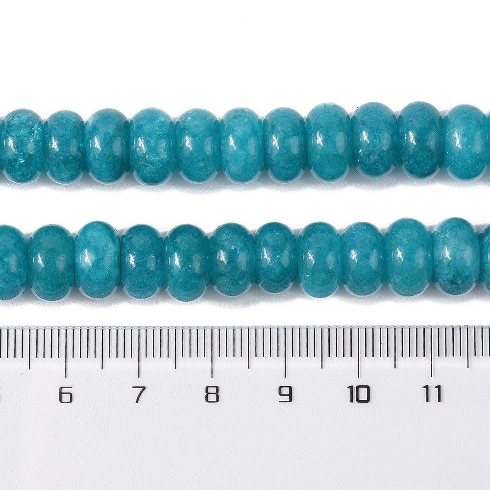 zoomed in sections of teal dyed jade rondelle strand above clear ruler over white surface. 