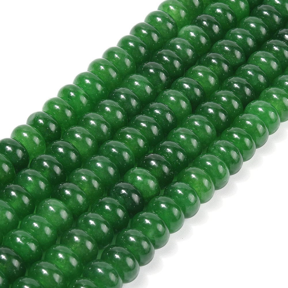 zoomed in sections of dark green dyed jade rondelle strands over white surface. 