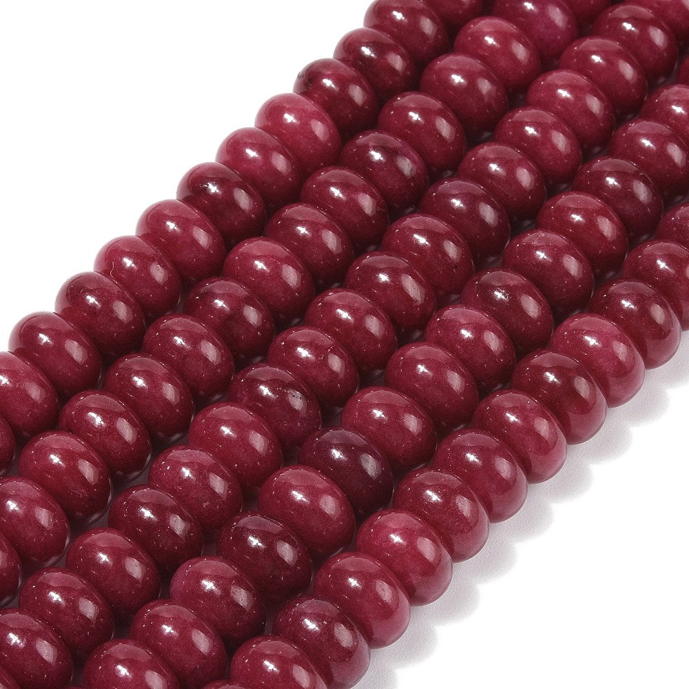 zoomed in sections of dark red dyed jade rondelle strands over white surface. 