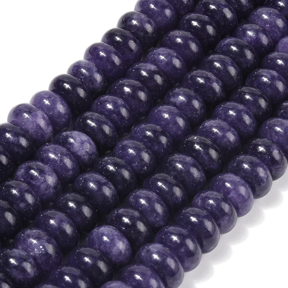 zoomed in sections of dark purple dyed jade rondelle strands over white surface. 