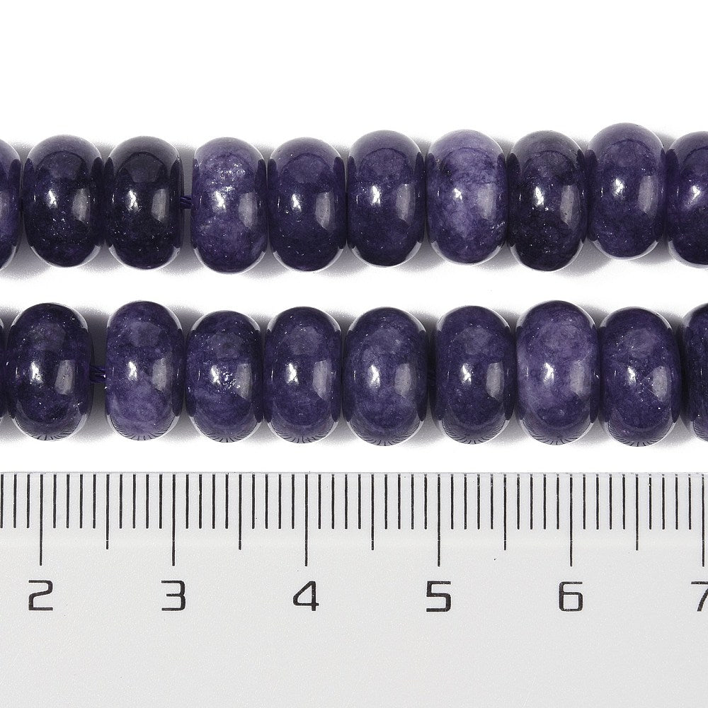 zoomed in sections of dark purple dyed jade rondelle strand above clear ruler over white surface. 