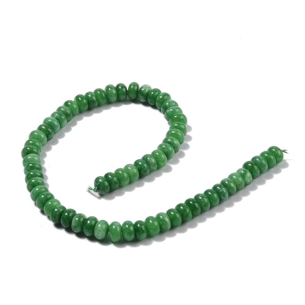 green dyed jade rondelle strand in swirl display over white surface. 