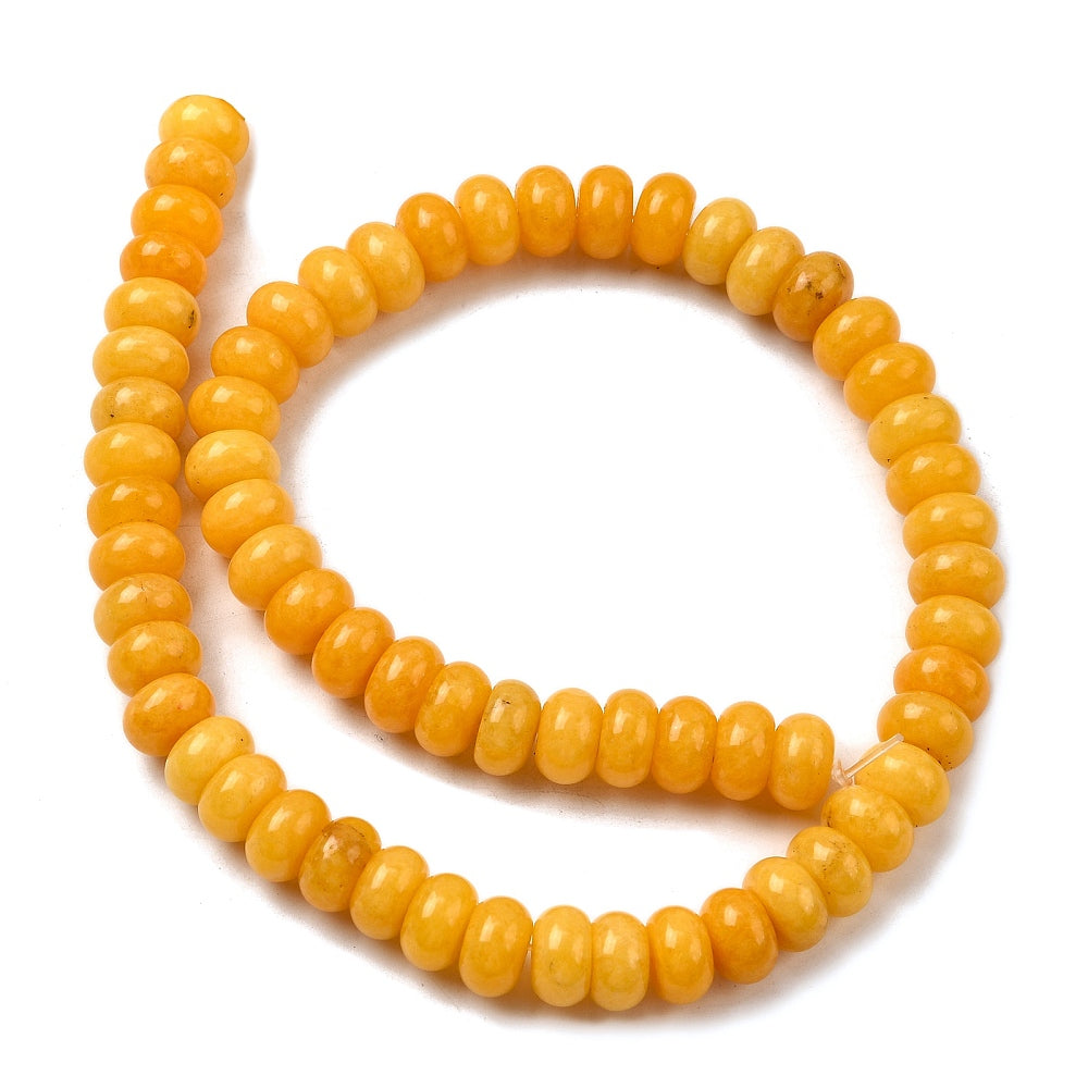 yellow dyed jade rondelle strand in swirl display over white surface. 
