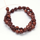 brown skull carved stone bead strand on white background. 