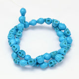 turquoise skull carved stone bead strand over white background. 