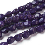 zoomed in sections of purple skull carved stone bead strands over white background. 