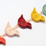 zoomed in section of multicolor magnesite bird bead strand over white background. 