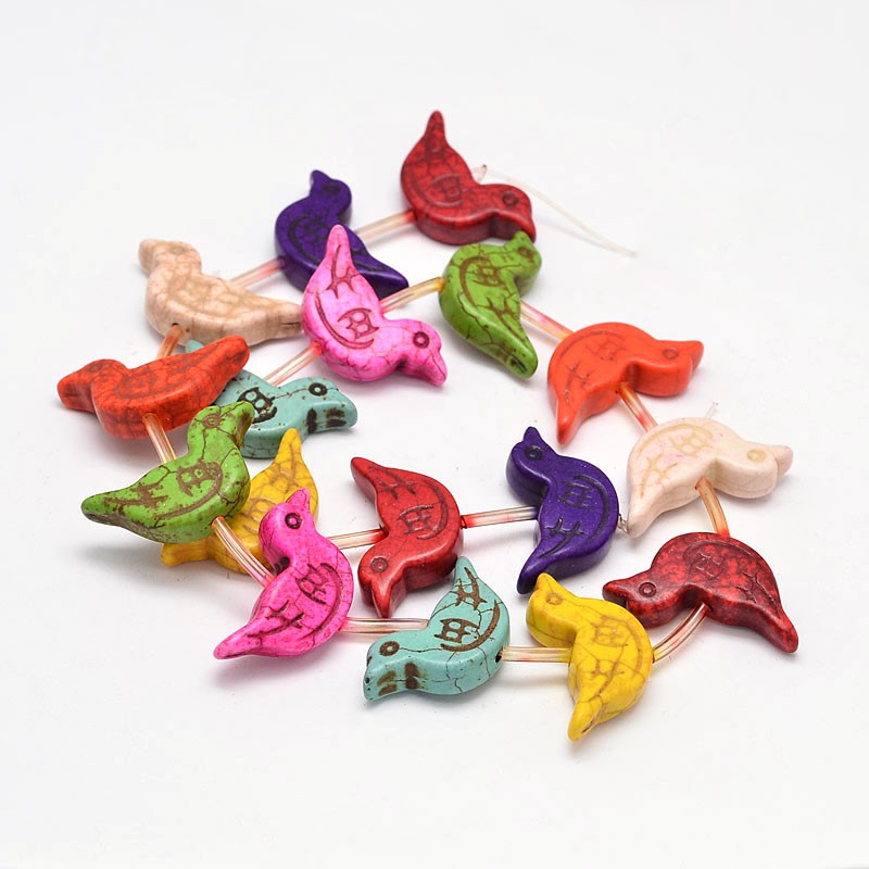 multicolor magnesite bird bead strand over white background. 