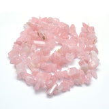 tumbled rose quartz large chip strand displayed in swirl design over white background. 