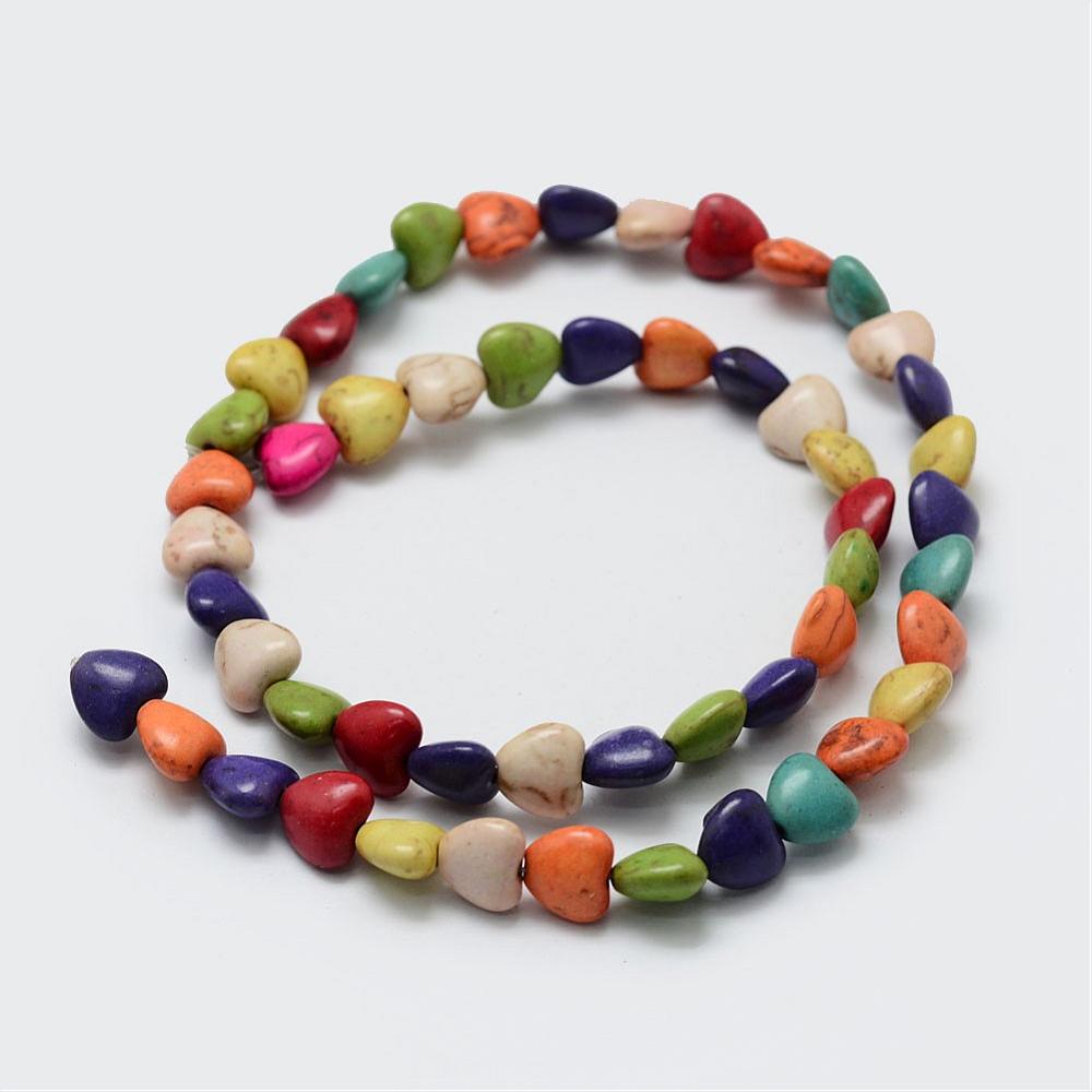 multicolor dyed magnesite heart stone bead strand in swirl design over white background. 