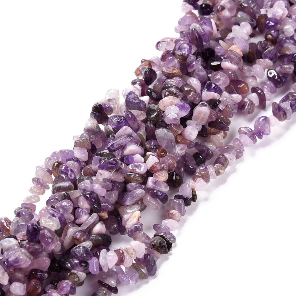 multiple strands of light purple tumbled amethyst chip beads twisted together over a white surface. 