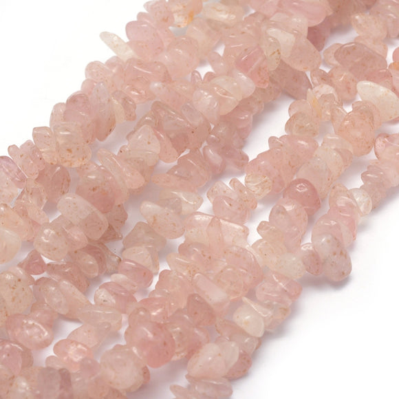 multiple light pink rose quartz chip strands over white background. 