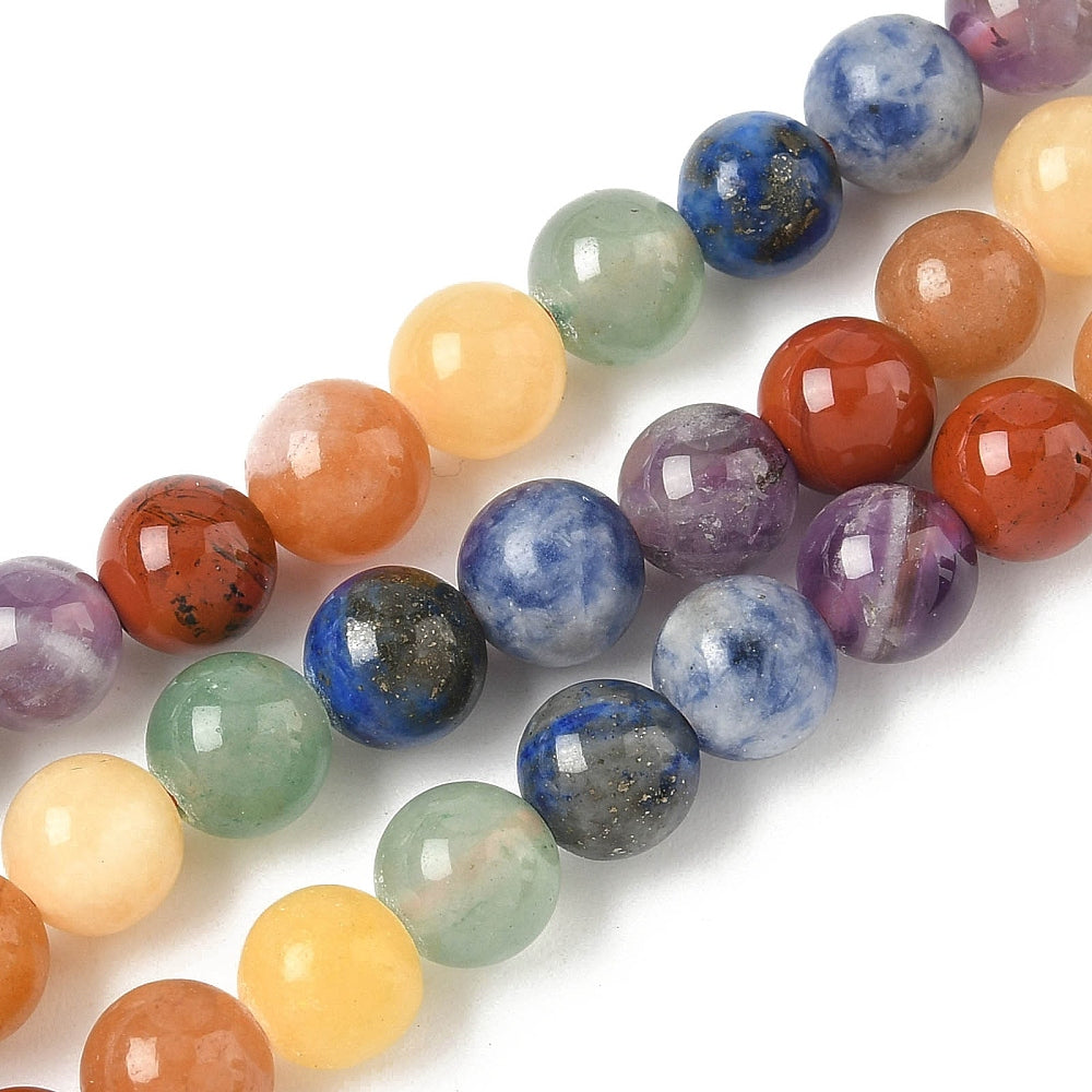 zoomed in sections of natural mixed gemstone chakra bead strand white surface. 