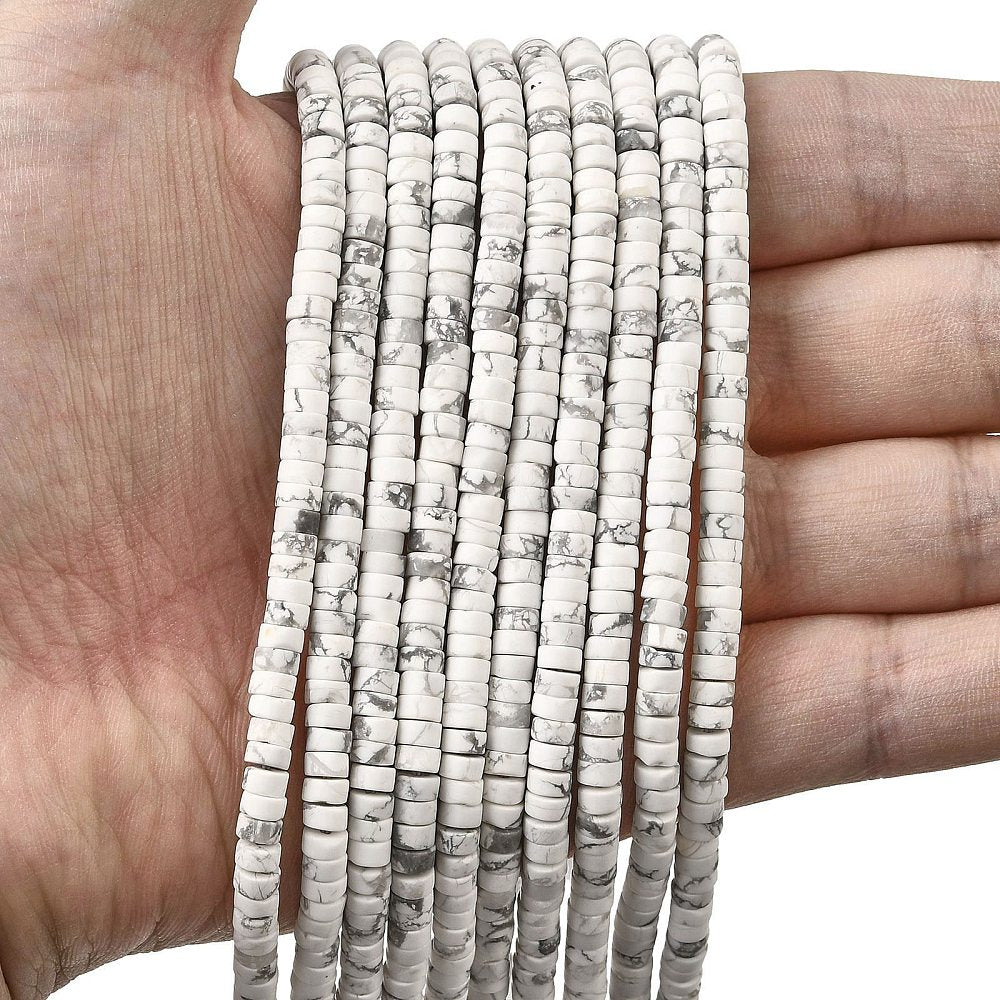 ten natural Howlite Heishi bead strands draped over a hand with a white background.
