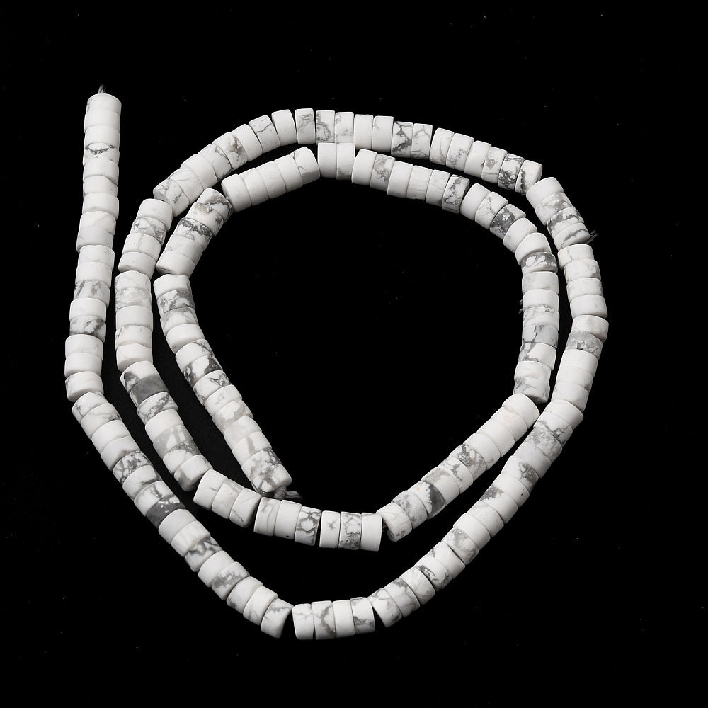natural Howlite Heishi bead strand in swirl design over black surface. 
