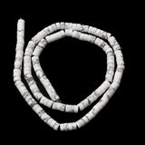 natural Howlite Heishi bead strand in swirl design over black surface. 