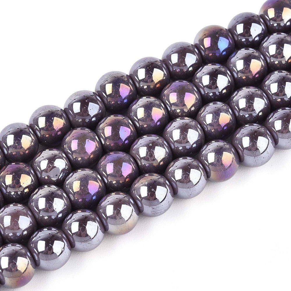 zoomed in sections of four iridescent  lavender glass bead strands over white surface.  