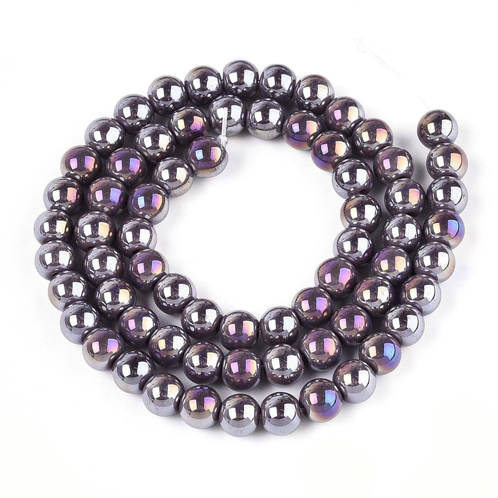 iridescent lavender  glass bead strand in swirl design over white surface.  
