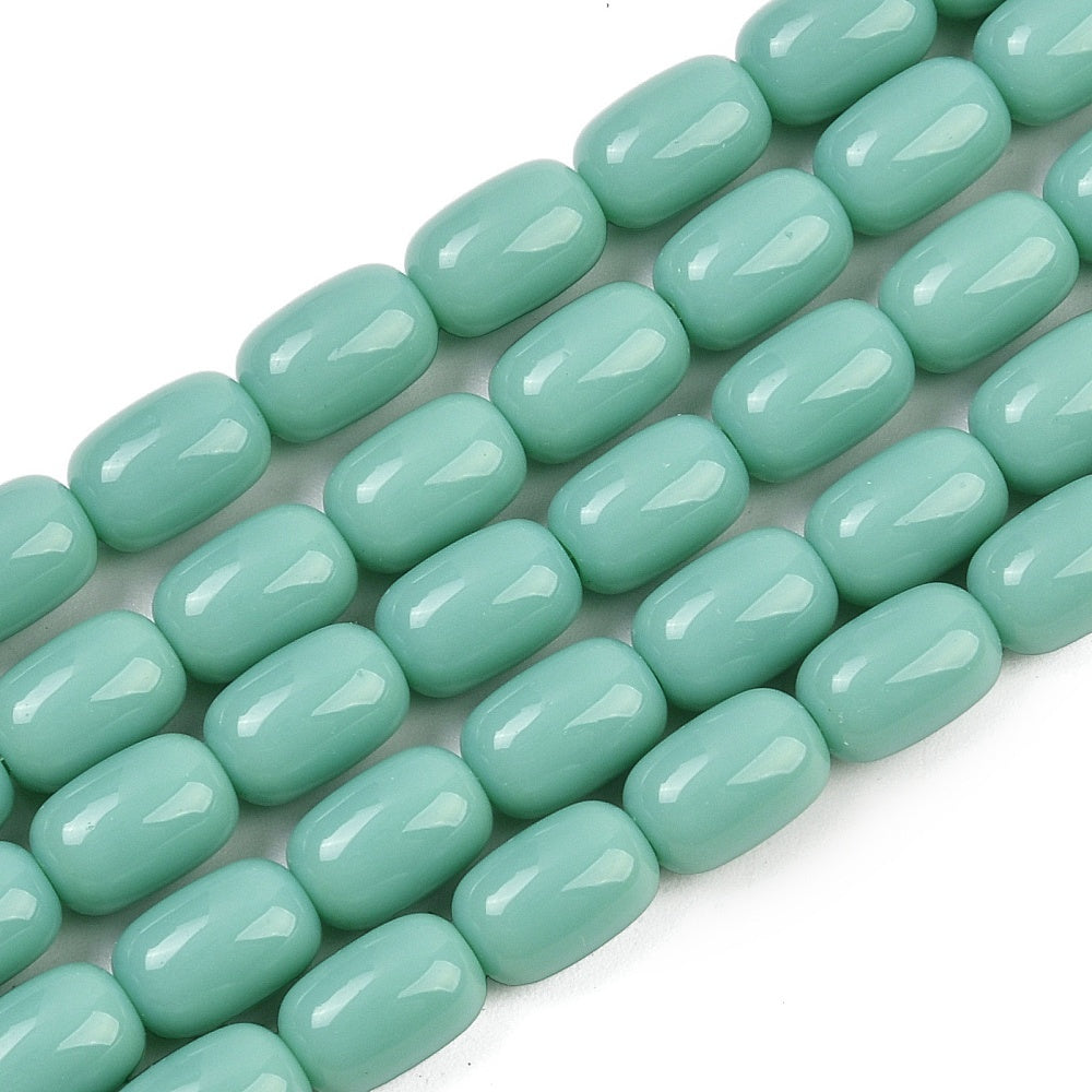 zoomed in sections of turquoise green barrel bead strands over white surface.