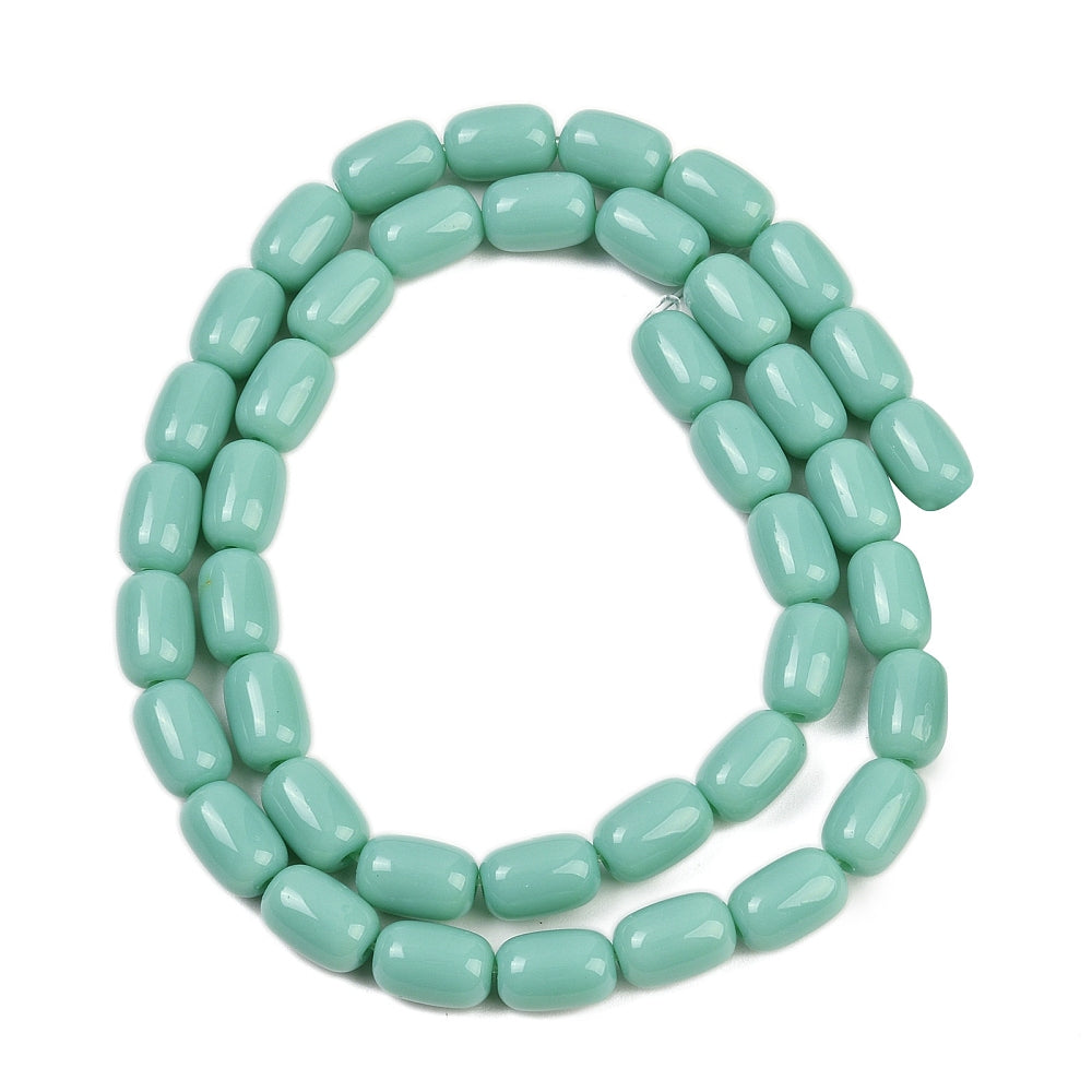 turquoise green glass barrel bead strand in swirl design over white surface. 