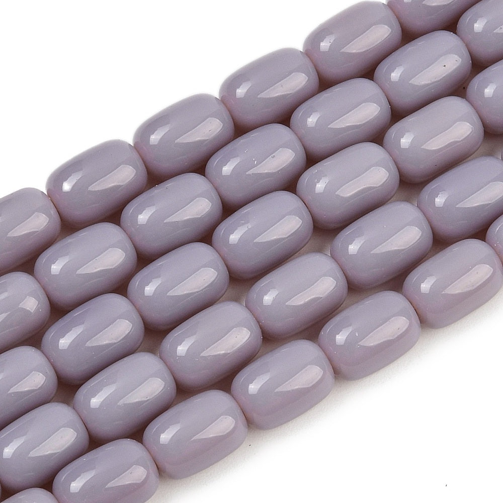 zoomed in sections of lavender barrel bead strands over white surface.