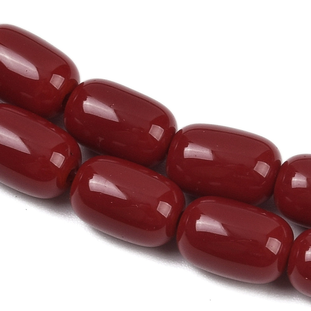 zoomed in sections of red barrel bead strands over white surface.