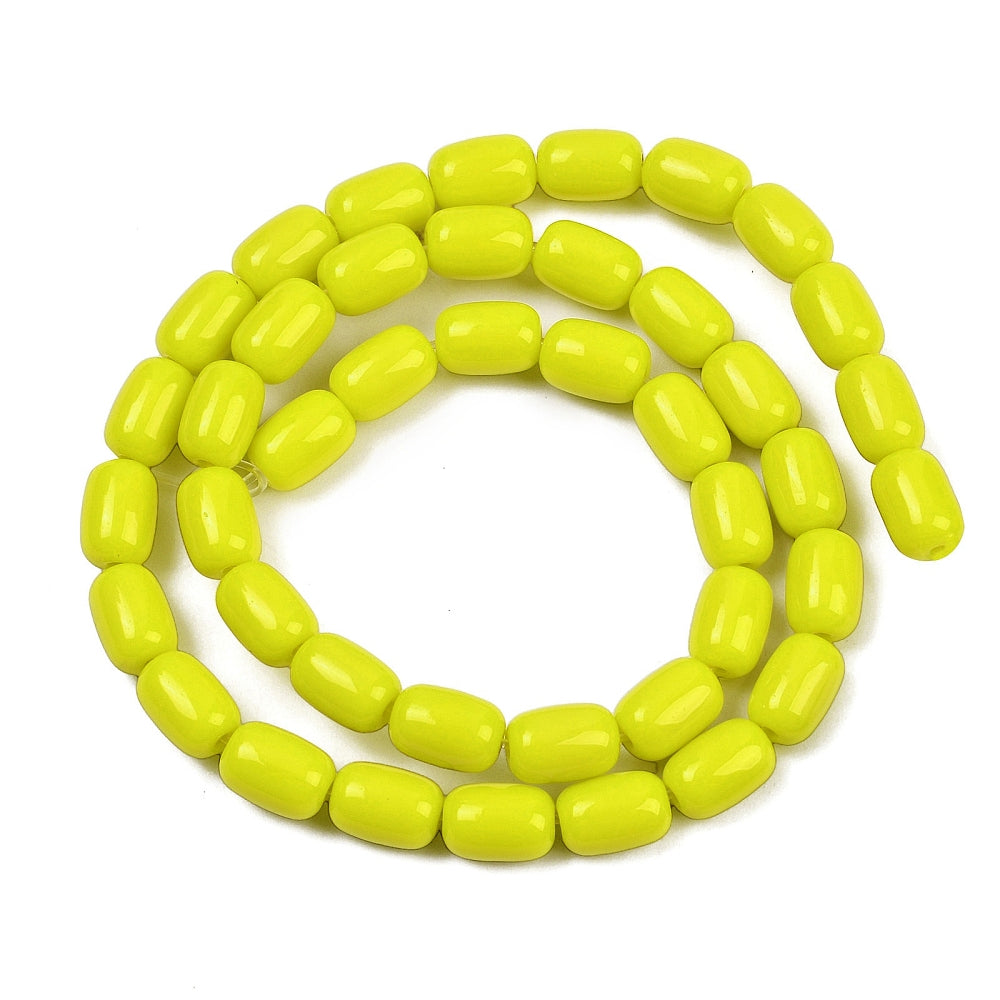 yellow glass barrel bead strand in swirl design over white surface. 