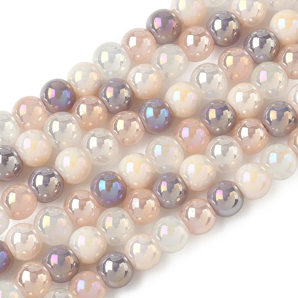 zoomed in sections of iridescent opaque pink and purple glass bead strands over white surface. 