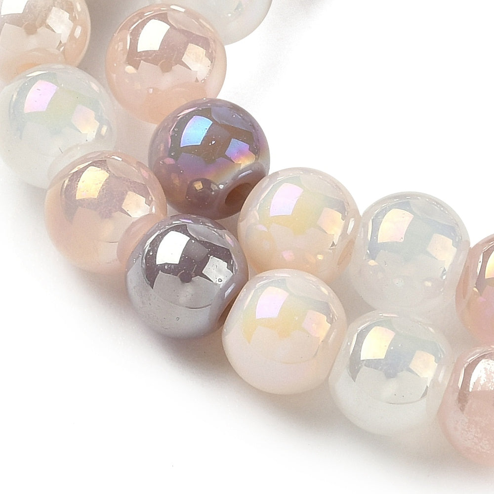 zoomed in sections of iridescent opaque pink and purple glass bead strand over white surface. 