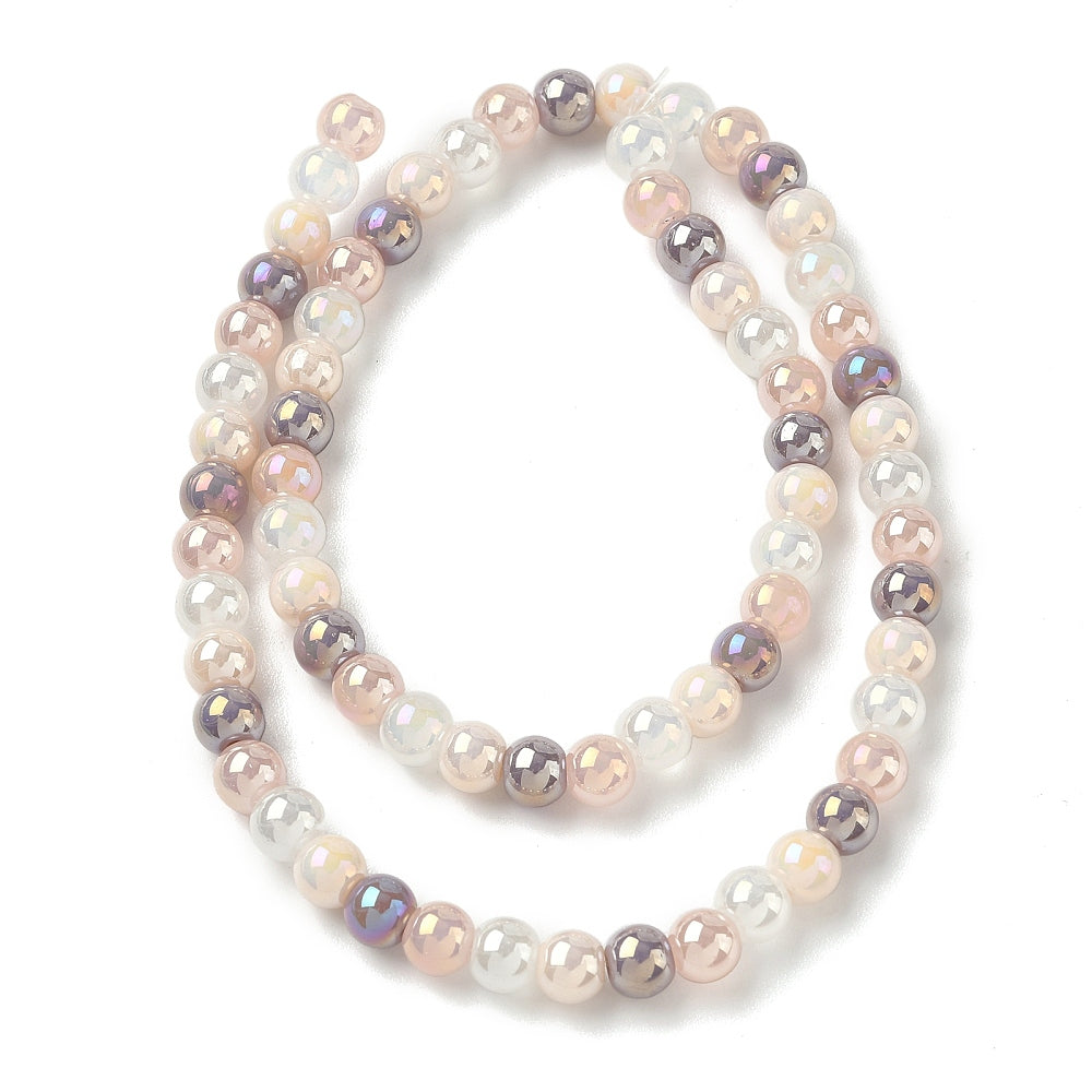 iridescent opaque pink and purple glass bead strand in swirl design over white surface. 