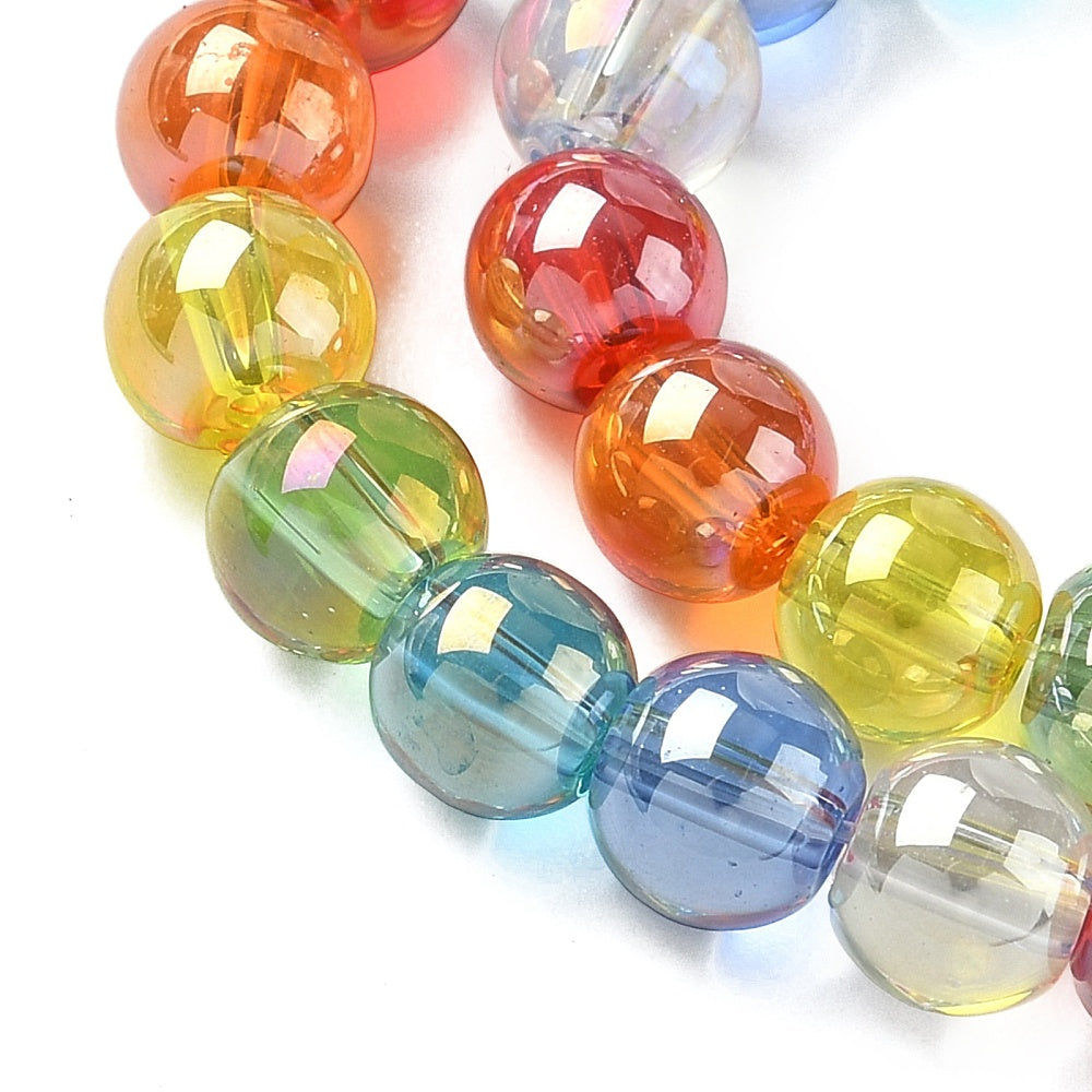 zoomed in sections of iridescent transparent rainbow glass bead strand over white surface. 