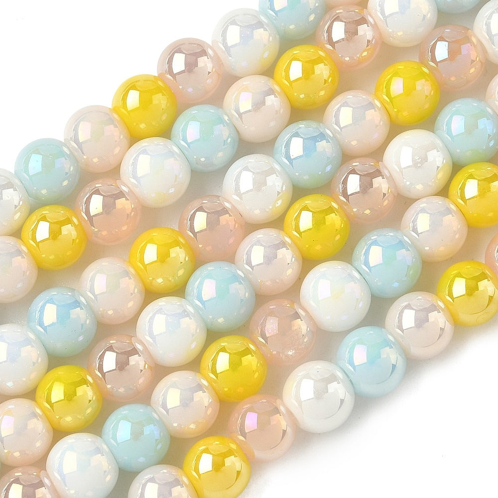 zoomed in sections of iridescent opaque blue sand yellow glass bead strands over white surface. 