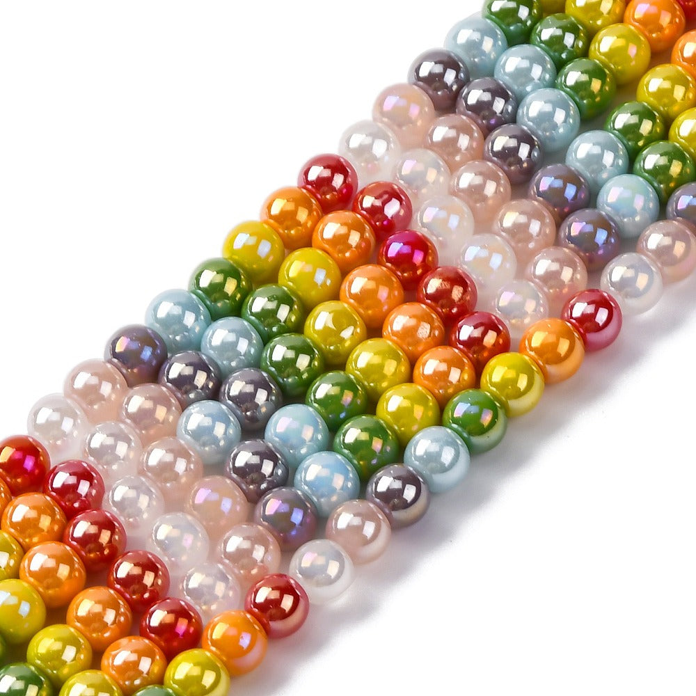 zoomed in sections of iridescent opaque rainbow glass bead strands over white surface. 